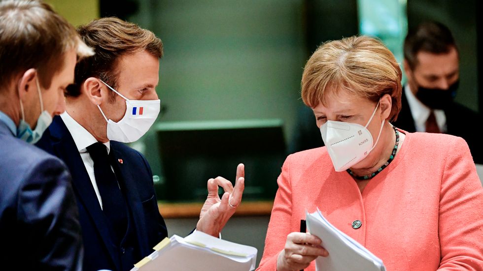 Frankrikes president Emmanuel Macron och Tysklands förbundskansler Angela Merkel studerar ett utkast till coronastöds- och budgetuppgörelse i Bryssel