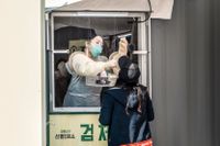 Sjukvårdspersonal i Seoul tar test för coronaviruset på personer som stannar till vid en mobil provtagningsstation, 3 april. 