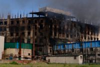 Rök stiger från den fabrik där en dödlig brand bröt ut utanför Dhaka, Bangladesh på fredagen.