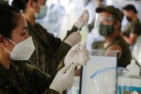 Militärläkare förbereder doser av det kinesiska företaget Sinovacs vaccin vid den filippinska militärens högkvarter utanför Manila den 2 mars.