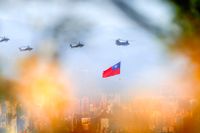 En helikopter flyger över Taiwan nära Taipei med en taiwanesisk flagga hängande i oktober 2021. Kina försöker infiltrera landets militär, rapporterar internationella medier. 
