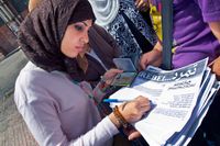 Asmaa Muhammad, student, skriver på Tamarods protestlista.