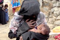 En kvinna ammar sitt undernärda barn i Jemen. Arkivbild.