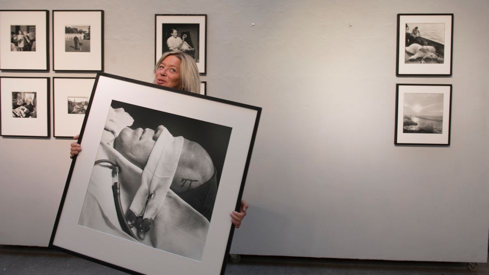 Anne Fjellström, verksamhetsansvarig på Lennart Nilsson Photography, förbereder utställningen på Galleri Kontrast. Här bär hon på en bild som skildrar en lobotomering på ett svenskt sjukhus.