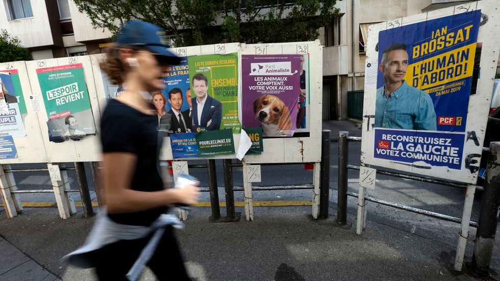 En kvinna passerar valaffischer inför valet till EU-parlamentet i Marseille i södra Frankrike.