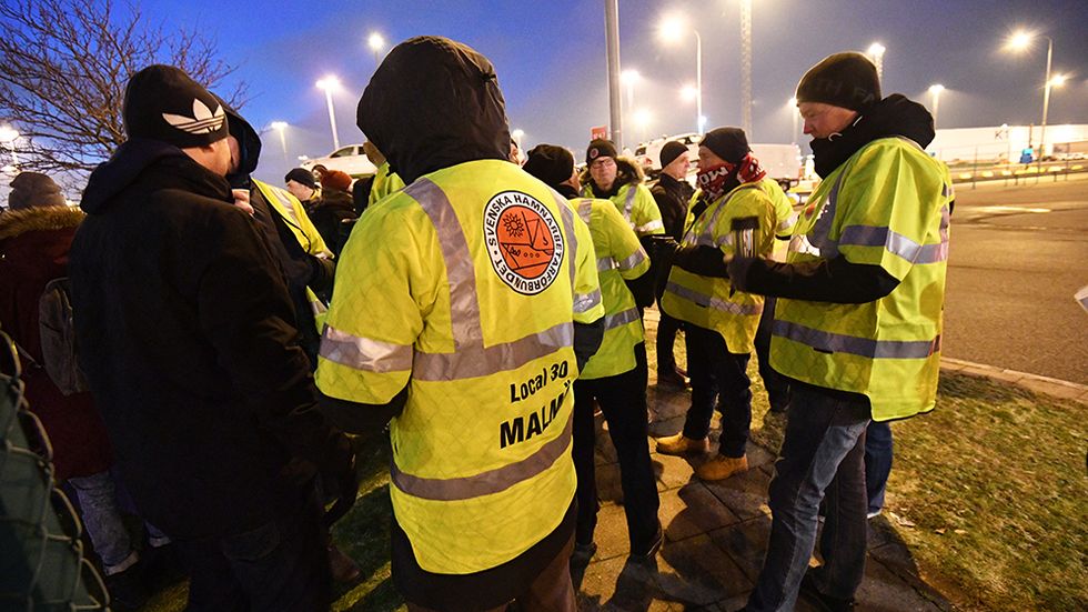 Strejkvakter utanför Malmö hamnområde den 23 januari. Hamnarbetarförbundet hade då nobbat slutbudet från medlarna, och strejk utbröt i 15 svenska hamnar. Samtidigt ligger ett förslag om att bland annat inskränka strejkrätten som kritiseras av artikelförfattarna. 