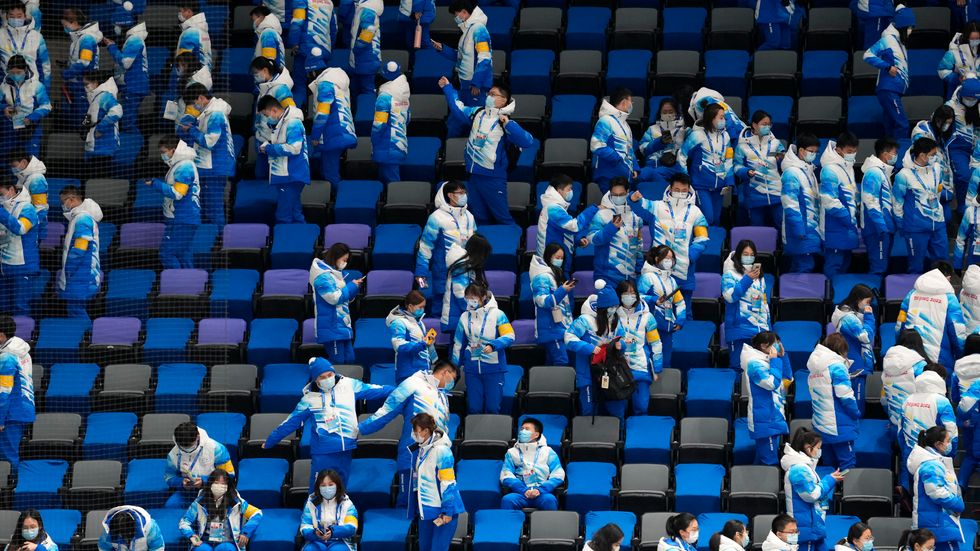 Volontärer på en OS-läktare i Peking. När vinterspelen drar igång får enbart inbjudna åskådare se tävlingarna.