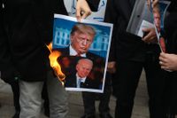 Demonstranter i Iran bränner en bild på USA:s nuvarande president Donald Trump och den tillträdande presidenten Joe Biden efter mordet på Mohsen Fakhrizadeh i Iran. USA:s allierade Israel har av Iran pekats ut som skyldig till mordet.
