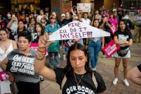 Protester i Kalifornien på fredagen. 18-åriga Yazmin Orozco håller upp en galge med orden: ”Okej, jag gör det själv.”