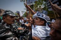 Indiska säkerhetsstyrkor håller tillbaka demonstranter i Dehli på fredagen.