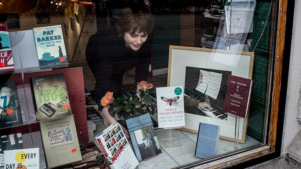 Stina Björkholm rättar till böckerna i skylfönstret på Hedengrens bokhandel i Stockholm.