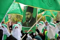 Palestinska studenter med en affisch på Hassan Al-Banna, grundaren av Muslimska brödraskapet, under en stöd­demonstration för Hamas. 