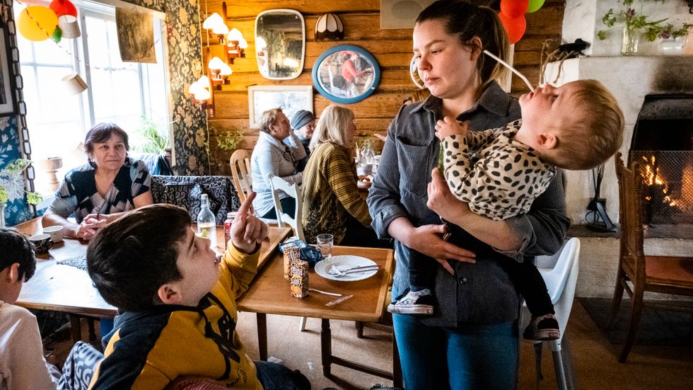 I Gustavsberg finns ett våffelkafé som brukar vara stängt på måndagar, men nu är det fullt av ukrainska flyktingar och värdfamiljer. Elin Hagberg har tagit emot en ukrainsk familj och sönerna hjälper till att passa Elins bebis. 