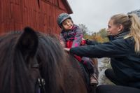 Malin Larsson och hennes dotter Tuva har drabbats av besparingarna inom assistansersättningen. Här får sexåringen rida på Lovön utanför Stockholm.