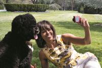 Michelle Obama med familjens hund på gräsmattan utanför Vita huset.