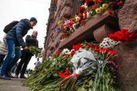 En man lägger ner blommor vid en minnesplats för offren för dådet i S:t Petersburgs tunnelbana.