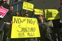 Demonstranter håller upp sina plakat utanför domstolen i San Francisco där Trumps order om fristäder behandlas.