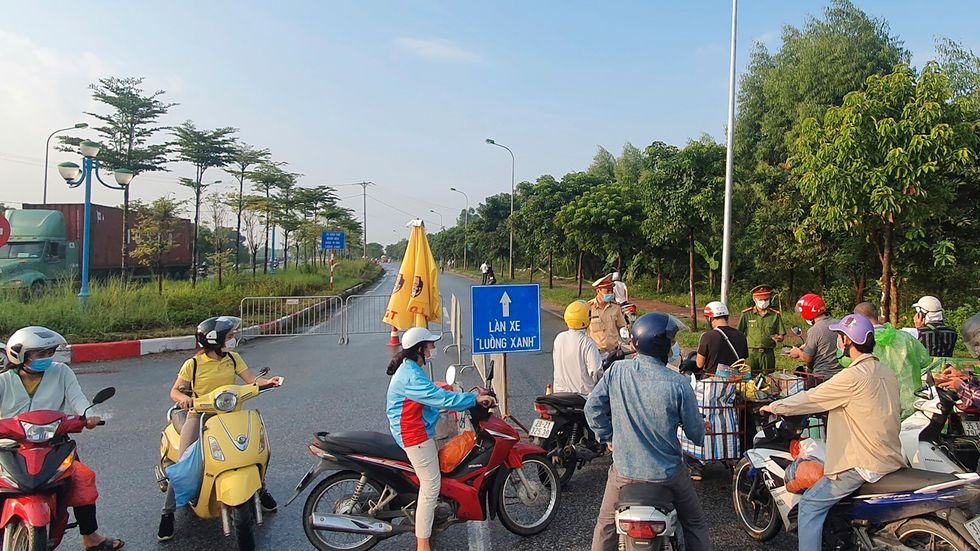 En vägspärr hindrar människor från att ta sig in i Hanoi, som stängde ner på lördagen för att stoppa virusspridningen.