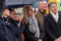 Håller ett skyddande SvD-paraply över Anna Dahlberg, Expressens politiska redaktör, vid Måndagsmötet på Norrmalmstorg.