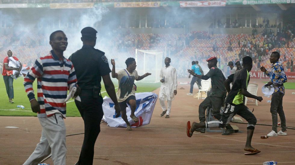Polis försöker stoppa planstormningen efter matchen mellan Nigeria och Ghana.