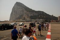 Turister på Gibraltars internationella flygplats, med Gibraltarklippan i bakgrunden.