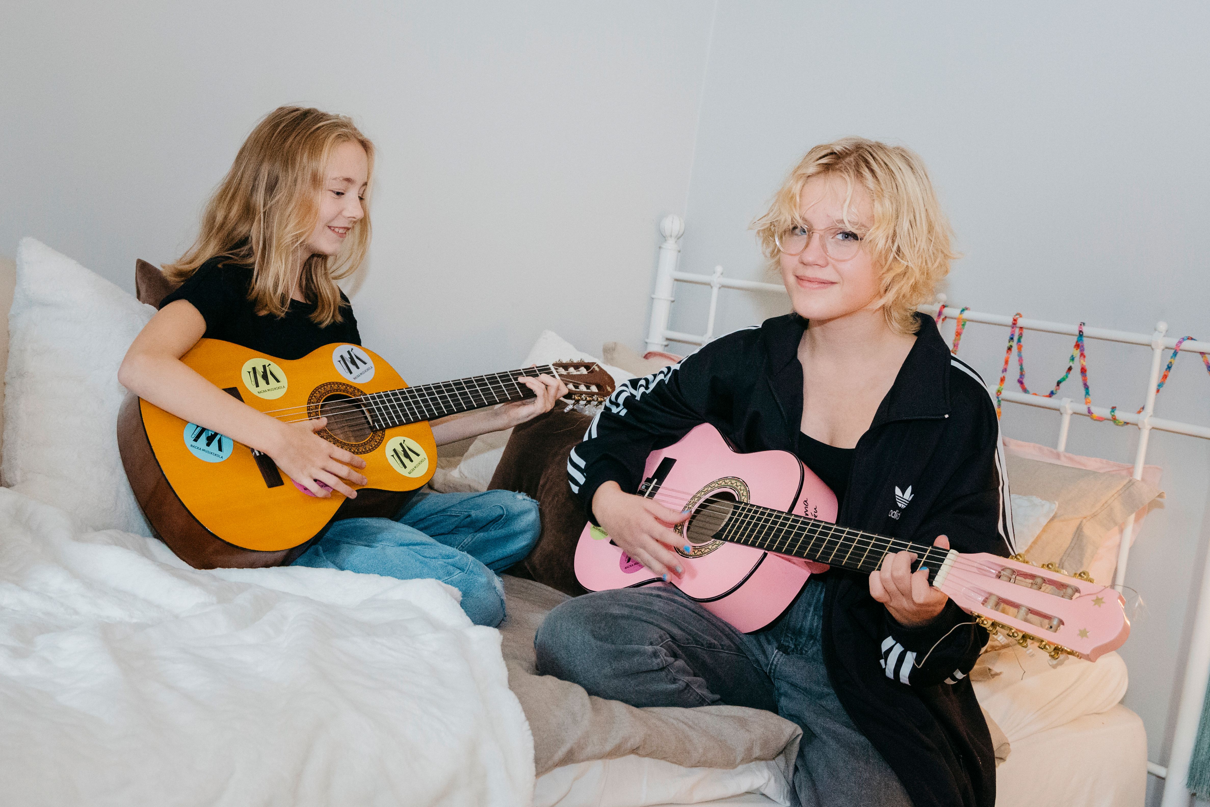 Moa, 11 år, och Emma, 12 år, har ägnat många timmar åt att spela gitarr det senaste året.