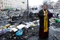 En präst ställde sig på tisdagen mitt emellan demonstranterna och kravallpolisen i Kiev.