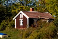 Ett rött hus med vita knutar är fortfarande mångas bild av hur ett fritidshus ska se ut. Arkivbild.