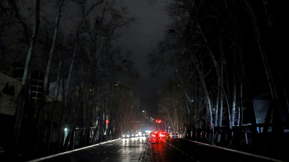 Bilar på en nedsläckt gata i iranska Teheran under ett strömavbrott den 20 januari.