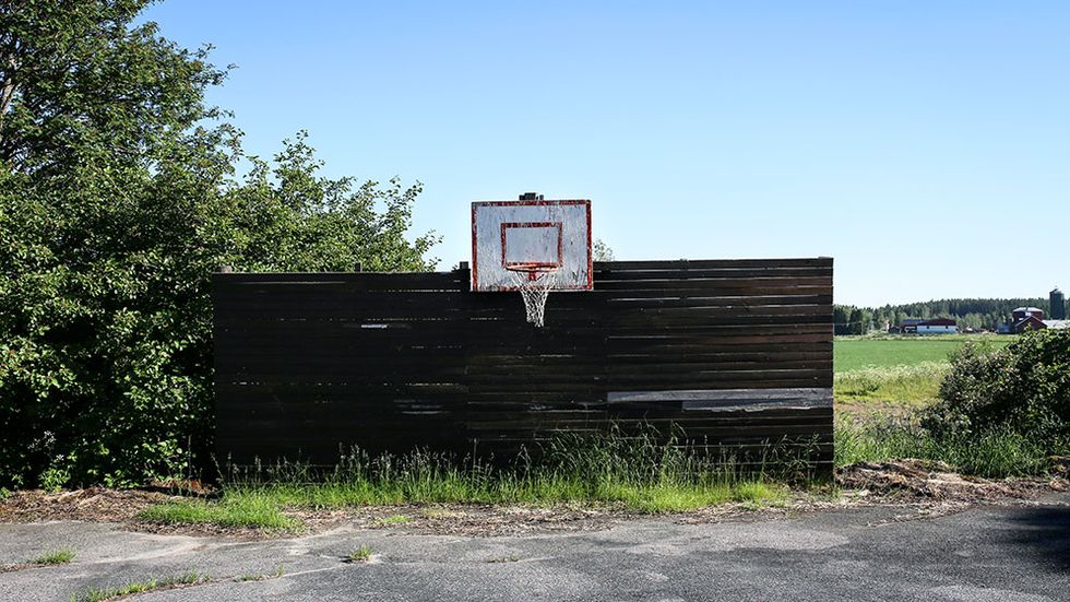 Övergiven basketkorg på skolgård vid stängd skola i Kalix kommun i Norrbotten.