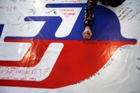 En kvinna skriver meddelanden på en lång banderoll som lades ut Kuala Lumpur efter att MH370 försvunnit.
