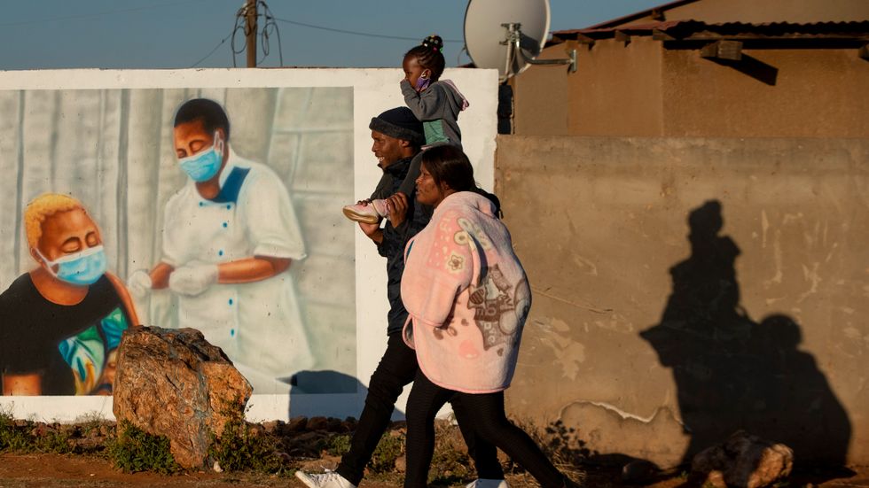 En familj passerar en muralmålning som uppmuntrar till vaccinering mot covid utanför Johannesburg, Sydafrika, på onsdagen. Liksom flera andra afrikanska länder drabbas Sydafrika av en tredje våg av pandemin.