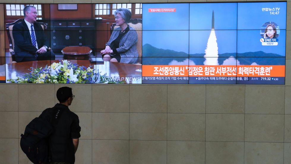 En man ser en projektil avfyras från Nordkorea på sydkoreansk tv tidigare i år. Arkivbild.