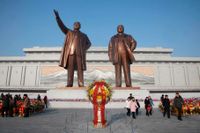 Blomsterhav framför statyerna av Kim Il-Sung och Kim Jong-Il.