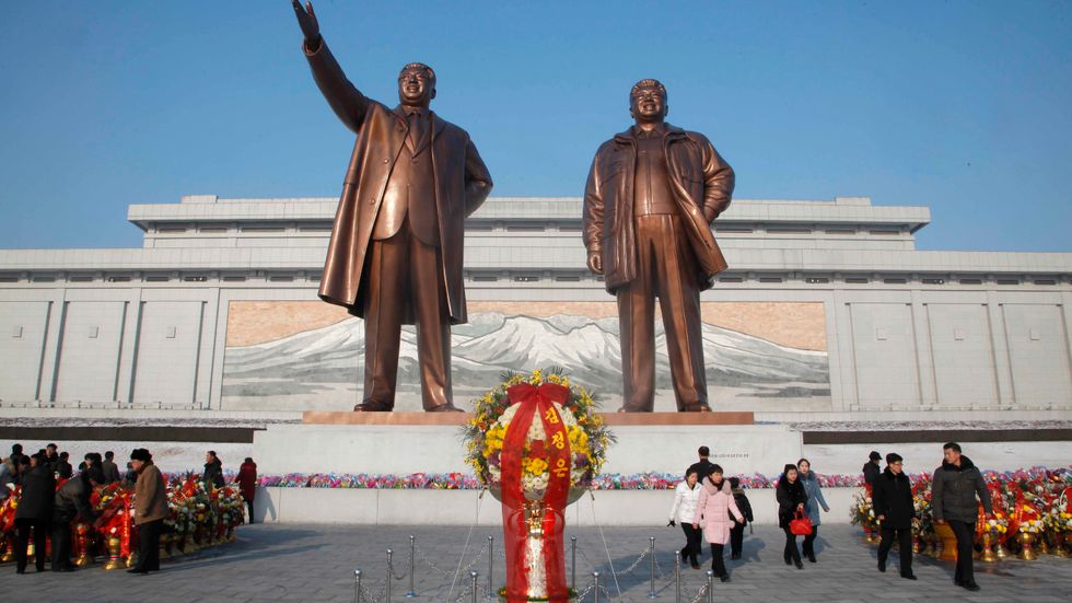 Blomsterhav framför statyerna av Kim Il-Sung och Kim Jong-Il.