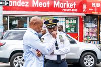 Demokraternas borgmästarkandidat Eric Adams talar med polisen i Queens, New York, efter en masskjutning den 1 augusti. 