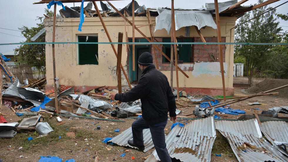 En man går förbi ett hus i azeriska Agdam som förstörts under striderna. Bild från 1 oktober.