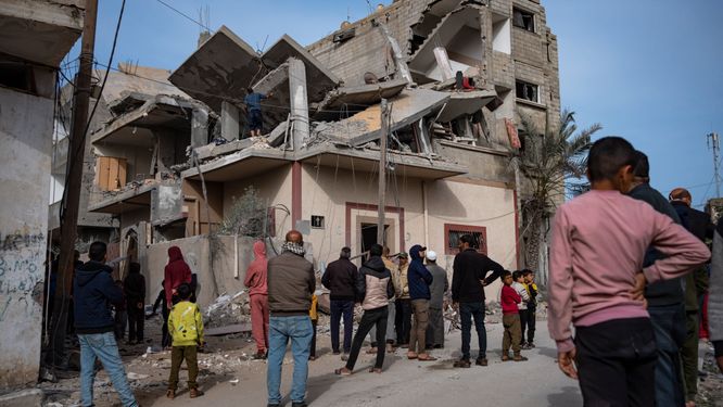 Palestinier letar efter människor under ett hus som attackerats av ett israeliskt luftangrepp i Rafah i Gaza.