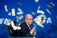 Den brittiske komikern Simon Brodkin kastade sedlar över Fifa-ordföranden Sepp Blatter under en presskonferens i Zurich.