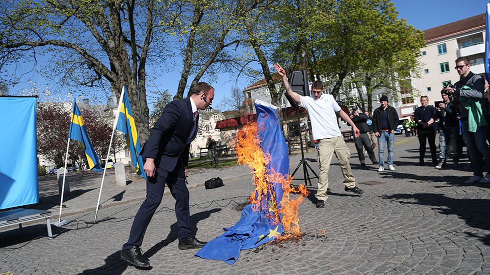 Partiledaren Stefan Jacobsson bränner EU-flagga vid högerextrema Svenskarnas Partis demonstration i Jönköping första maj.