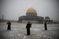 En grupp kvinnor har snöbollskrig utanför klippmoskén i Jerusalem.