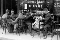 På bara några få veckor har turisterna flytt från Paris. Ovan några soldater fotograferade 30 juli 1914  på ett kafé.