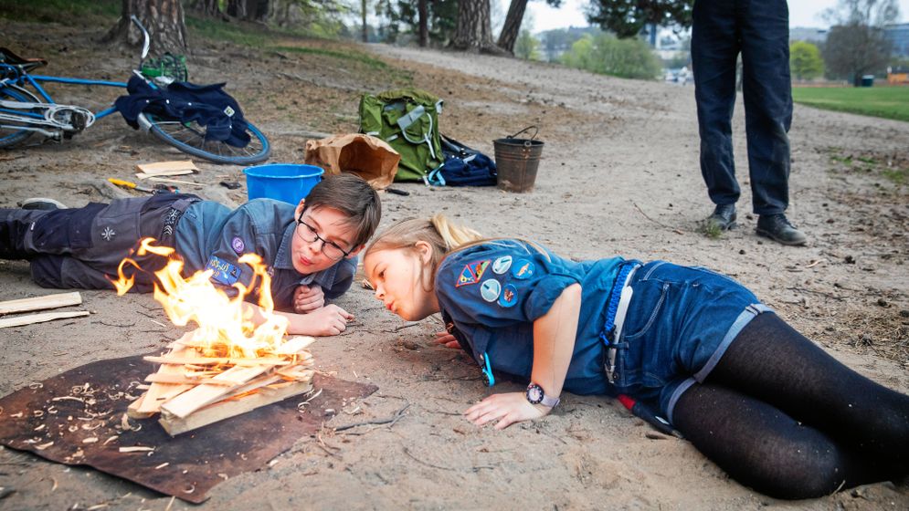 Finn och Sigrid blåser på lågorna för att elden ska ta fart.