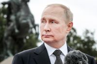Rysslands president Vladimir Putin vid ett tal i samband med en militärparad i Sankt Petersburg den 31 juli. I bakgrunden en staty av Peter den store till häst.