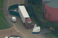 Brittisk polis undersöker lastbilscontainern där 39 personer hittats avlidna.