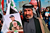 En anhängare till den irakiska milisen Hashid al-Shaabi med en bild på dess tidigare befälhavare Abu Mahdi al-Muhandis och den iranske generalen Qassem Soleimani.