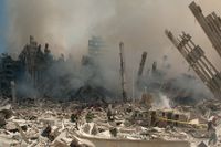 Brandmän röjer bland spillrorna efter de rasade World Trade Center-tornen i New York, dagen efter terrordådet den 11 september 2001.