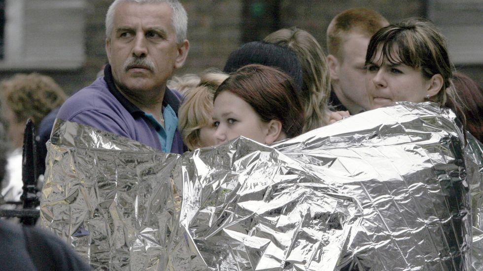 Evakuerade bär nödfiltar efter att en dubbeldäckarbuss sprängts av en självmordsbombare. Det bara en timme efter tre andra koordinerade självmordsattacker i Londons tunnelbana.