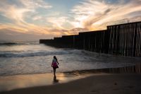 En flicka vid gränsmuren som separerar San Diego och Tijuana i Kalifornien. Arkivbild.