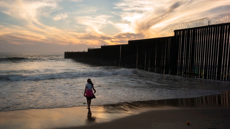 En flicka vid gränsmuren som separerar San Diego och Tijuana i Kalifornien. Arkivbild.